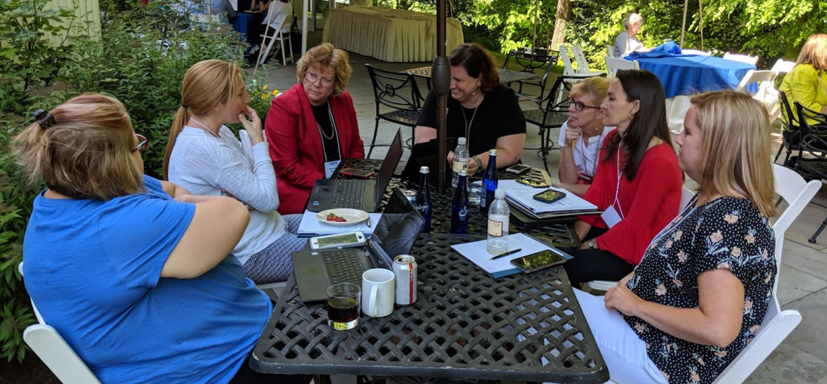 Group of women sitting at a picnic table talking