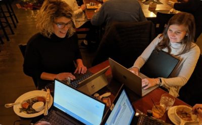 Two women taking notes during a workshop